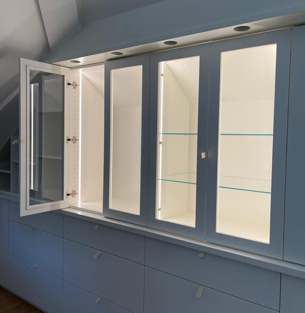 Dachschrägen-Einbau mit beleuchteten Glasvitrinen