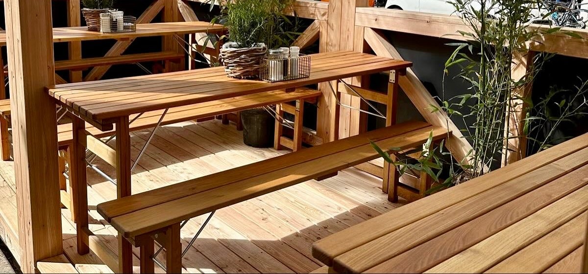 Bänke und Tische auf dem Deckboden unter dem Lattendach